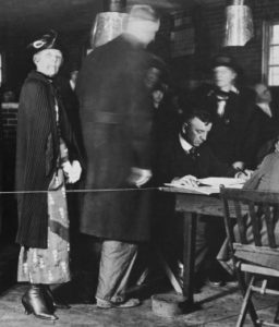 Florence Harding stares up at a photographer while waiting in line to vote for her husband as president in 1920.