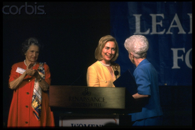 Lady Bird Johnson applauds Hillary Clinton during a September 1996 campaign appearance, during which she greets Texas Governor Ann Richards at the podium.