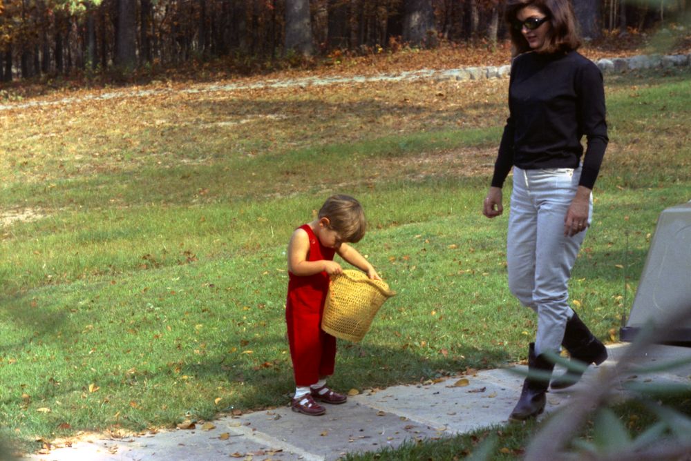 John Kennedy searching for his turtle in the basket as his mother approaches.