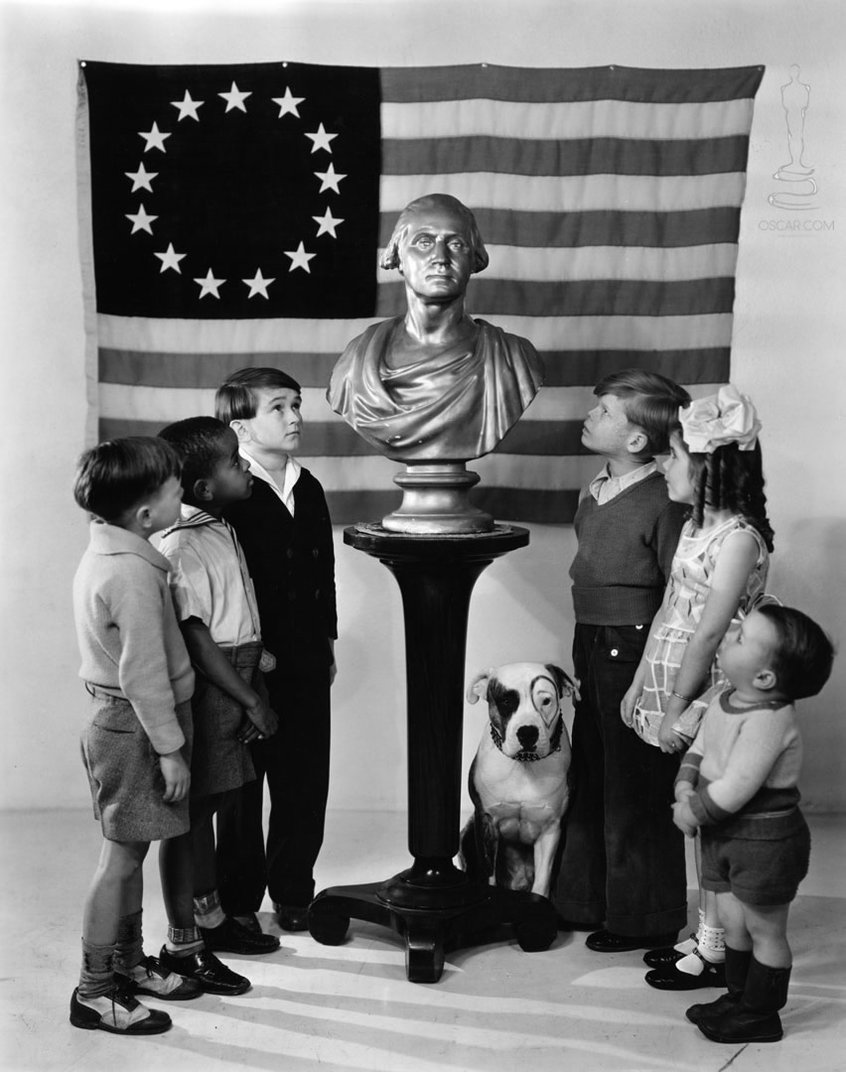 In honor of George Washington's birthday bicentennial, members of the Our Gang comedy troupe stand in awed attention at his bust in 1932.