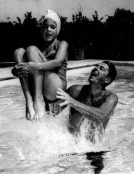 Reagan catches his daughter Patti as she jumps into the pool.