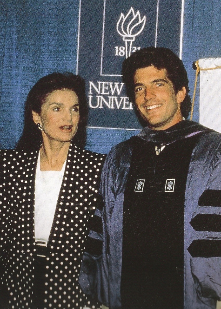 At his New York University Law School graduation, Jackie Onassis prompted her son to say a few words to acknowledge the good wishes of the gathered press there. At his New York University Law School graduation, Jackie Onassis prompted her son to say a few words to acknowledge the good wishes of the gathered press there.