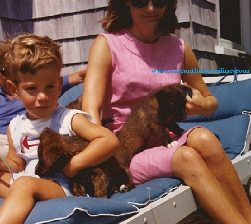 Jackie Kennedy and her son John hold a pair of puppies, August 1963. Jackie Kennedy and her son John hold a pair of puppies, August 1963.
