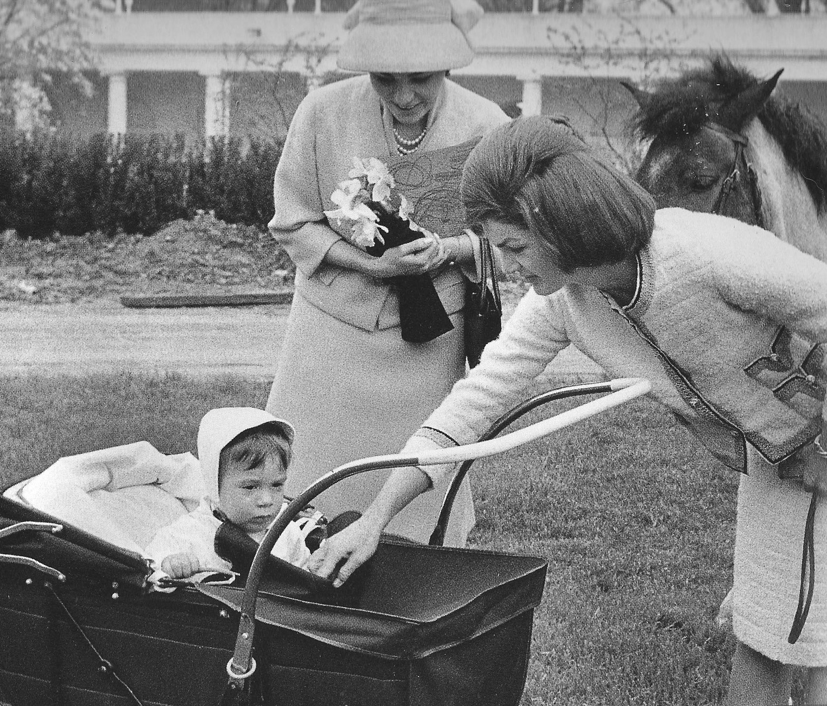 The First Lady introduces her two-year old son to the Shah of Iran's wife on the White House South Lawn, 1962. The First Lady introduces her two-year old son to the Shah of Iran's wife on the White House South Lawn, 1962.
