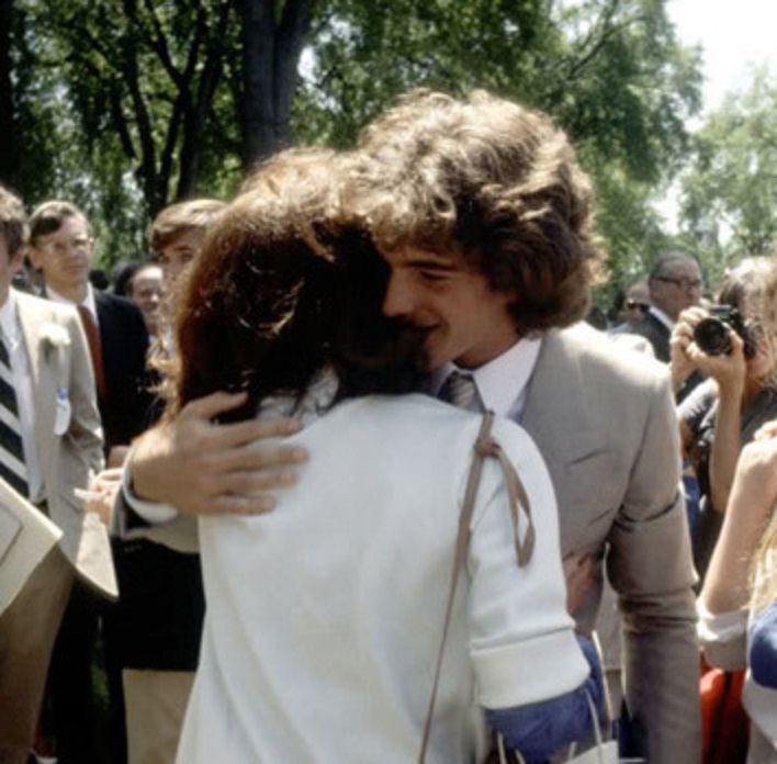 After ditching his cap and gown John hugs his mother at his high school graduation, 1979. After ditching his cap and gown John hugs his mother at his high school graduation, 1979.