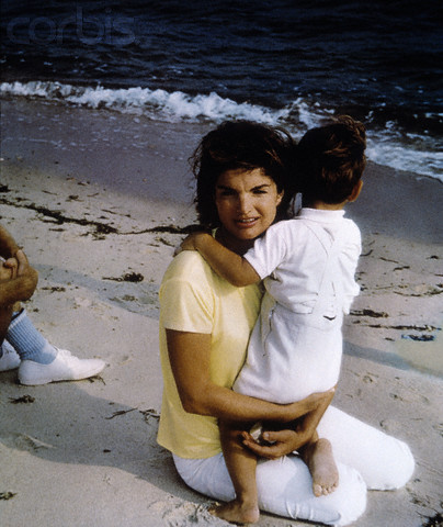 Jackie holds John during their first summer without Jack, at Hyannis Port, 1964.