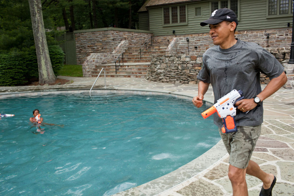 President Obama running around the Camp David pool with a water gun, shooting daughter Sasha in the water.