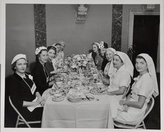 A very young Jackie Kennedy, seated at the end of the right row, next to Lady Bird Johnson, in the nurse outfit always worn when The Senate Ladies gathered to roll bandages for the Red Cross.