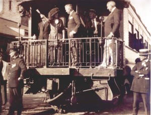 Florence Harding boldly gesturing to the Governor of Wyoming during the stop in Cheyenne on June 25, while President Harding modesty remains at the side.