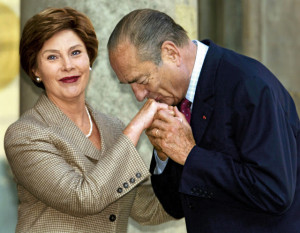 French President Jacques Chirac kissing the hand of Laura Bush.