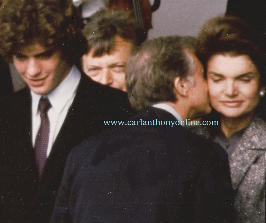 President Jimmy Carter kisses former First Lady Jacqueline Kennedy Onassis W
