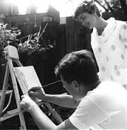 Jackie Kennedy takes a closer look at her husband's oil painting of some row houses; JFK did not turn out many finished canvases. Unlike those of Churchill and President Eisenhower, almost none outside of his family are known to exist.