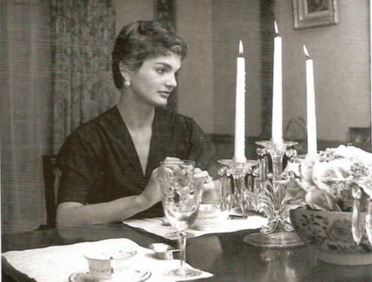Pausing at her table set for dinner guests.