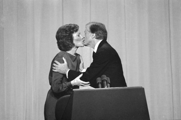 The Carters kissing at the presidential podium after both making remarks during the Carter Administration.