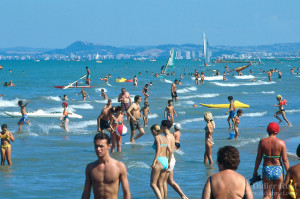A crowded beach during the final summer of the century of the 20th century.  